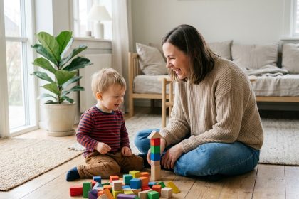 Maman et son enfant jouent avec des blocs en bois dans un salon lumineux